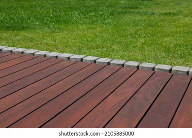 Teak wood deck detail next green grass, natural exotic hardwood lumber outdoor flooring - Shutterstock ID 2105885000