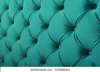 Teal blue capitone textile background with buttons, retro Chesterfield style soft tufted fabric furniture upholstery diamond pattern decoration, close up
