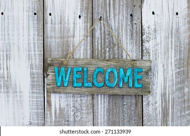 Teal blue welcome sign hanging on white painted weathered wood background - Powered by Shutterstock