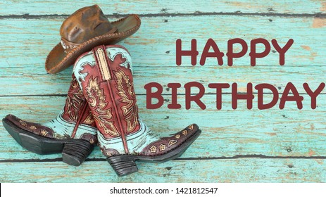 teal and brown cowboy boots and hat laying flat on a wooden teal background with happy birthday in brown text