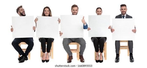 Team of 5 businessmen holding empty billboards and one of them screaming while sitting on chairs on white studio background - Powered by Shutterstock