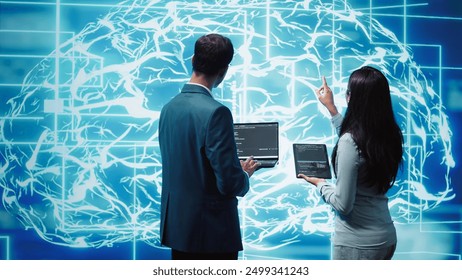 Team of admins using tablet and laptop to maintenance artificial intelligence neural networks. Teamworking IT staff members using AI system aiding in processing and transmitting information, camera B