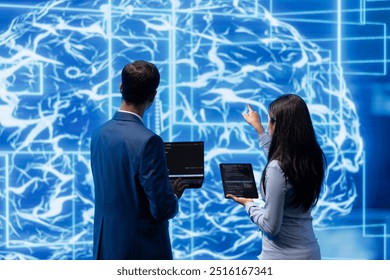 Team of admins using tablet and laptop to do maintenance on artificial intelligence neural networks. Teamworking IT staff members using AI system aiding in processing and transmitting information