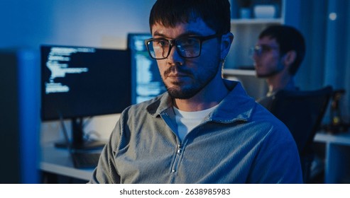 Team adult male freelance developer work late typing write prompt AI bot app program nomad terminal code at office night. Artificial intelligence dashboard, robotics, user interface, machine learning.