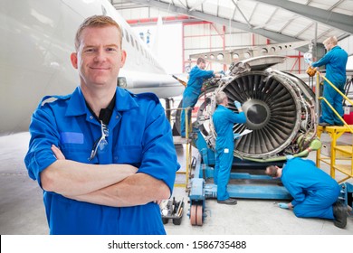 Team Of Aero Engineers Working On Aircraft In Hangar