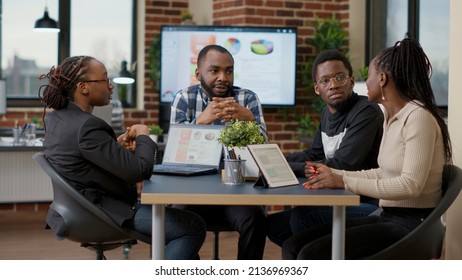 Team of african american businesspeople meeting in boardroom office to discuss strategy and work plan, creating financial project with statistics. Colleagues doing teamwork to analyze sales data. - Powered by Shutterstock