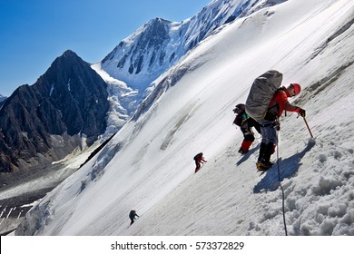 Team of alpinists climbing a mountain with snow field