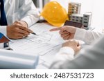 Team architects discuss a house plans blueprint and modern building model in the office, development low residence projects, design home custom of customer, build a housing estate.