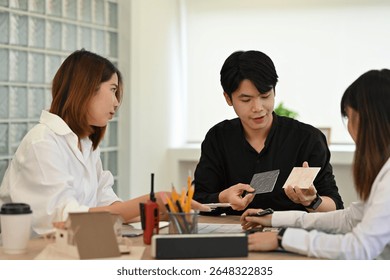 Team of architects evaluating tile samples for an interior design project during a creative meeting at a modern workspace.