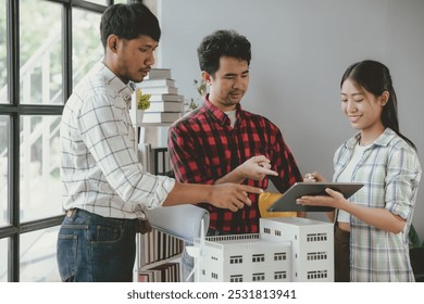 Team of architects using digital tablet and model while working on a project in the office