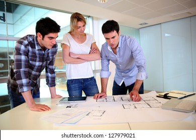 Team of architects working on construction plans - Powered by Shutterstock