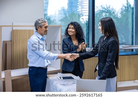 Team of architectures, engineer, interior designer and businessmen handshaking over finalize the floor plan modification for real estate renovating investment and housing development project concept