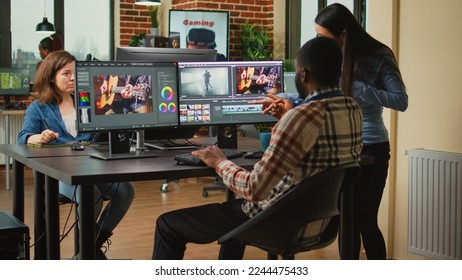 Team of artistic content creators editing movie montage on software, brainstorming ideas to improve focus and lighting. Man and woman working with post production video and audio footage. - Shutterstock ID 2244475433