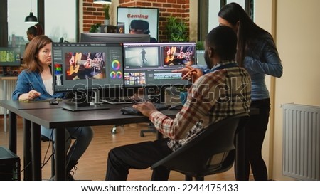 Team of artistic content creators editing movie montage on software, brainstorming ideas to improve focus and lighting. Man and woman working with post production video and audio footage.