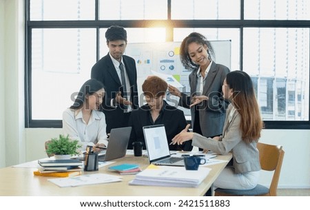 Team of asian business working with document paper sitting at desk in office in meeting room, Business team working with project statistics, Asian business team and present graphic info in room.