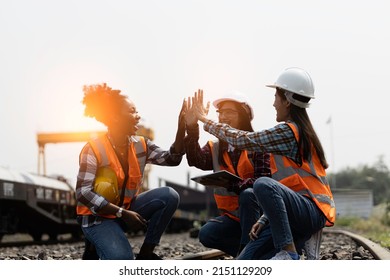 Team Of Asian Female Engineers And Black Female Engineers Are Happily Working On The Train Machines With Great Success.