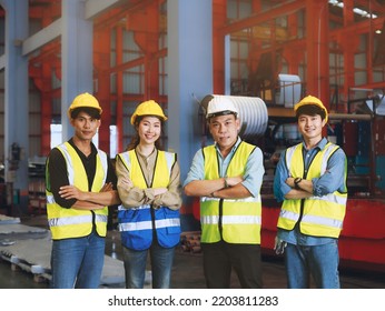 A Team Of Asian Male And Female Factory Workers Stand With Confidence And Success. In The Heavy Machinery Industry, Warehouse, Workshop, Factory Operators Mechanical Engineering Team Work Concept