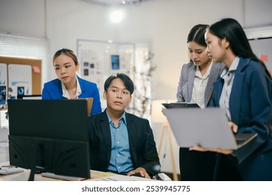 Team of asian professionals is collaborating on a project, analyzing data and discussing strategies in a modern office environment - Powered by Shutterstock