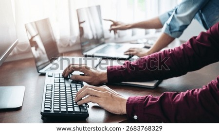 Team of asian programmer working together about new project to writing code of website or applications on laptop while pointing on laptop and brainstorm to programming in software development office