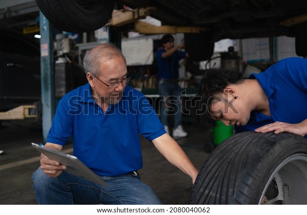 Team Asian at Service center, car repair,\
tire change. Mechanic changing engine, service car workshop\
automobile. professional man shop\
maintenance	
