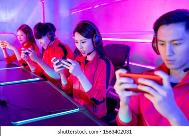 Team Of Asian Teenage Cyber Sport Gamers Play Mobile Game By Smartphone On ESport Tournament