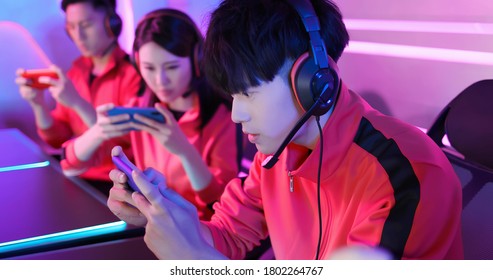 Team Of Asian Teenage Cyber Sport Gamers Play Mobile Game By Smartphone On ESport Tournament