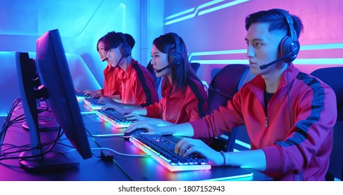 Team of asian teenage cyber sport gamers play in multiplayer PC video game on eSport tournament