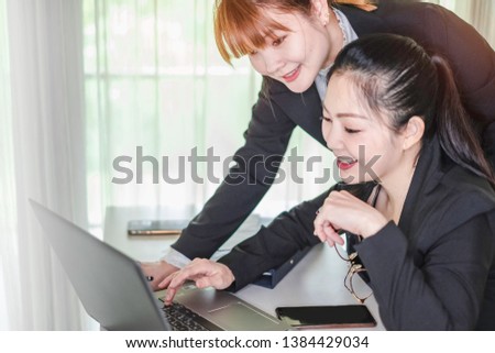 A Team of Asian workingwomen working together at computer laptop. The successful businesswomen learning about e-commerce/e business as online technology is changing. Teamwork& collaboration concept.
