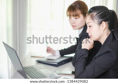 A Team of Asian workingwomen working together at computer laptop. The successful businesswomen learning about e-commerce/e business as online technology is changing. Teamwork& collaboration concept.