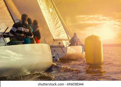 Team Athletes Participating In The Sailing Competition - Match Race.Two Sailing Yachts Round The Buoy. Sailboat At Sunset. Recreational Water Sports, Extreme Sport Action. Healthy Active Lifestyle. 