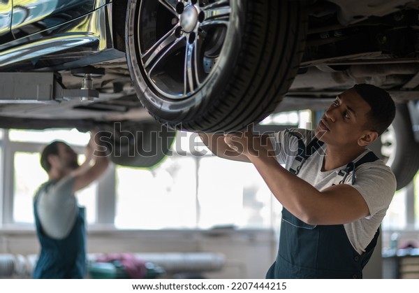 Team of\
auto mechanics fixing the customer\
vehicle