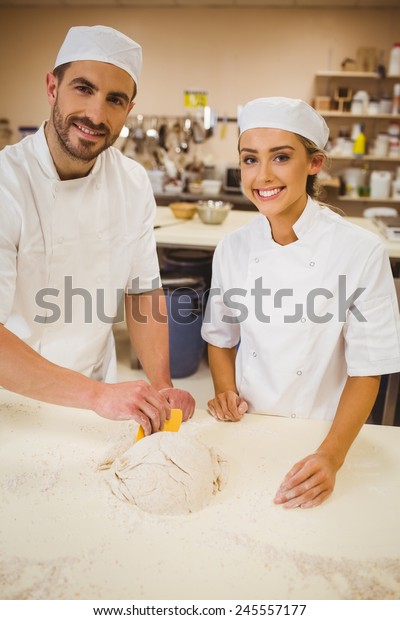Team of\
bakers preparing dough in a commercial\
kitchen