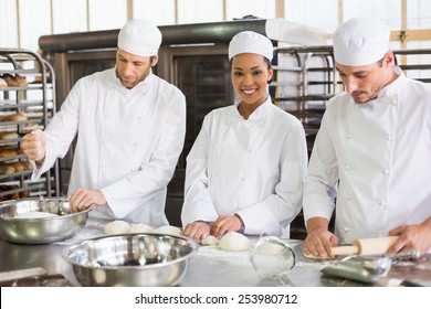 Team of bakers preparing dough in the kitchen of the bakery - Powered by Shutterstock