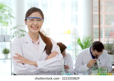 Team of biology researcher and scientist doing the biotechnology experiment in laboratory, cheerful Asian female scientist crossed arms and smiling to camera while in laboratory.  - Powered by Shutterstock