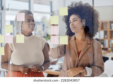 Team, brainstorming and business people with glass board, writing ideas on sticky note with collaboration and strategy. Planning, meeting and women working together, female employees and partnership - Powered by Shutterstock