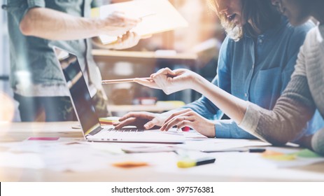 Team brainstorming. Photo young creative managers crew working with new startup project in modern office. Contemporary notebook on wood table. Horizontal, film effect - Shutterstock ID 397576381