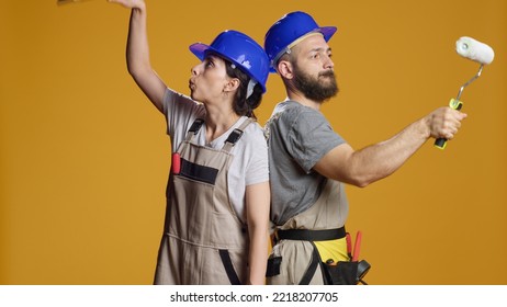 Team Of Builders With Refurbishment Skills Painting Walls With Paintbrush And Roller, Using Brush And Color To Renovate. Constructors Working On Redevelopment And Building In Studio.