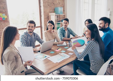 Team Building Concept. Meeting Of Colleagues, All Of Them Are  In Casual Clothes, Smiling And Discussing The Company`s Development Strategy At Nice Cozy  Office