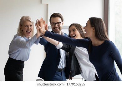 Team Building, Synergy, Cooperation And Unity Concept. Happy Co-workers Multi-ethnic Young Adult Staff Members Friendly Associates Give High Five Celebrating Achievement, Corporate Success And Advance