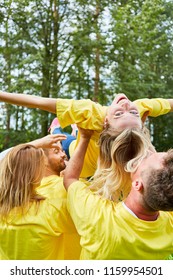 Team in the team building workshop trains confidence and makes woman float