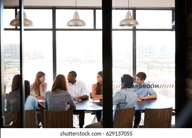 Team In A Business Boardroom Meeting Seen Through Glass Wall