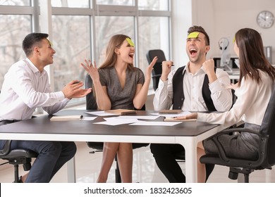 Team of business people playing "who I am" game in office - Powered by Shutterstock