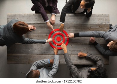 Team Of Business People Pointing At Red Target At Meeting Table