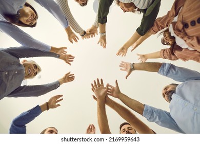 Team Of Business People Reaching Up Together. Group Of Young And Mature People Joining Hands, White Background, Cropped Low Angle Shot, From Below Bottom View Close Up. Teamwork, Participation Concept