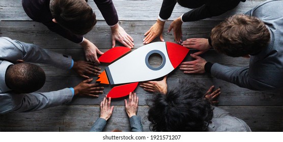Team of business people with rocket as a sumbol of high risky goals targets success at meeting table