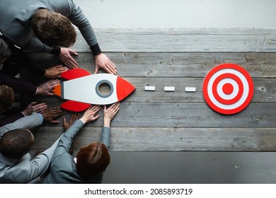 Team of business people with rocket as a sumbol of high risky goals targeting at red target at meeting table - Shutterstock ID 2085893719