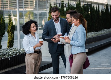 Team Of Business People Standing Outside In Front Of Office Buildings Talking And Having Coffee Brake.