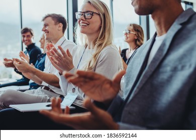 Team of businesspeople clapping hands while having a conference. Business professionals applauding at a seminar.