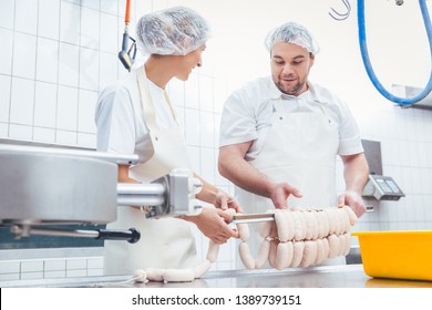 Team of butchers, woman and man, filling sausage in meat industry - Powered by Shutterstock