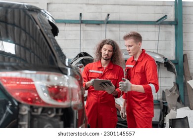 Team car mechanic man in red uniform checking and discussing rear window broken of car at garage auto service. Car repair and maintenance concept. - Powered by Shutterstock